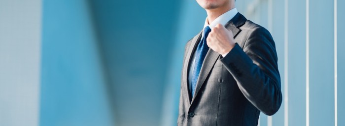 グッと手を握るスーツ男性